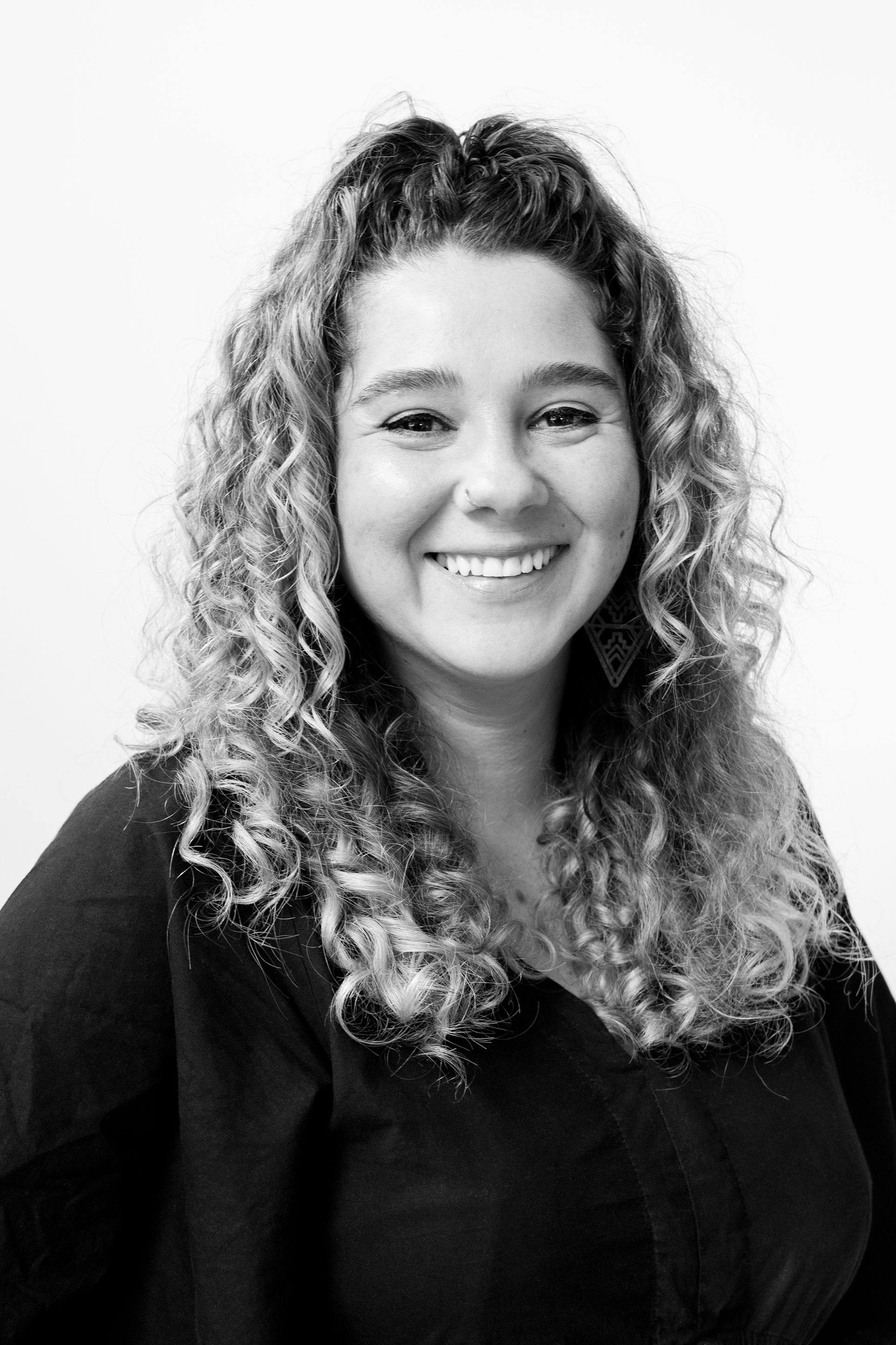 A woman in a green shirt is smiling for the camera