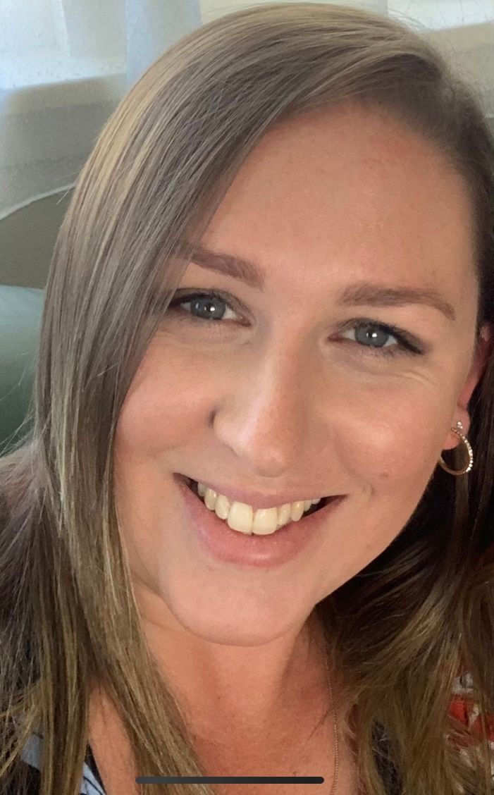 A close up of a woman 's face smiling for the camera.