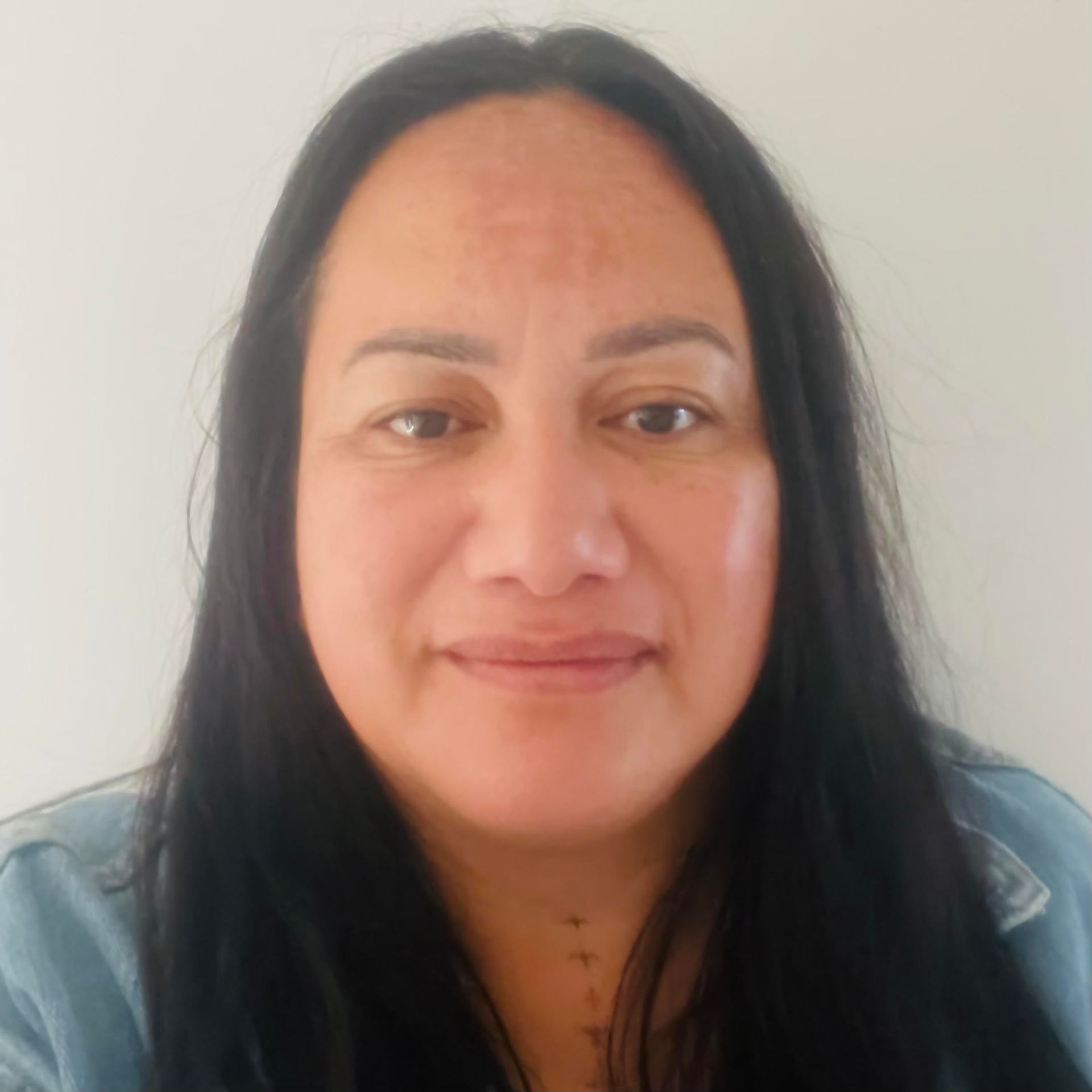 A woman with long black hair is smiling for the camera.
