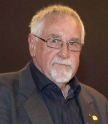 A man with glasses and a beard is wearing a suit