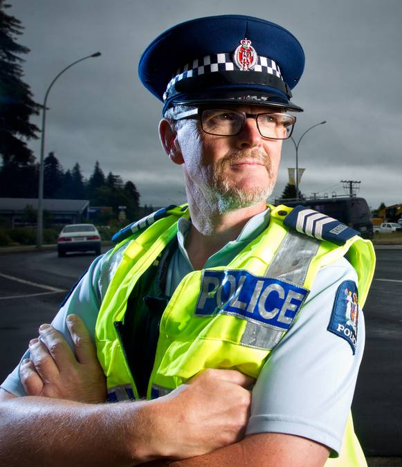 A man in a police uniform with his arms crossed