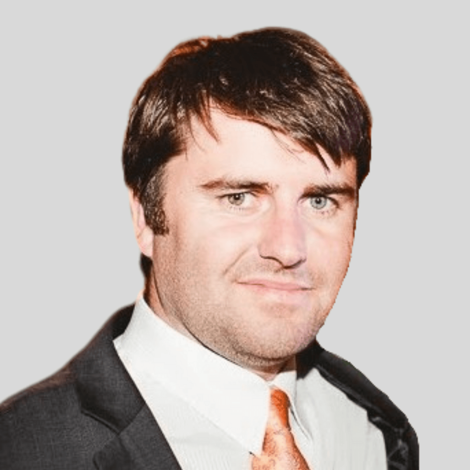 A man in a suit and tie is smiling for the camera