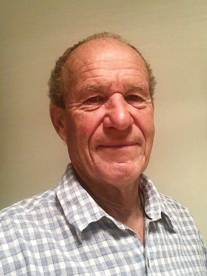 A man in a plaid shirt is smiling for the camera.