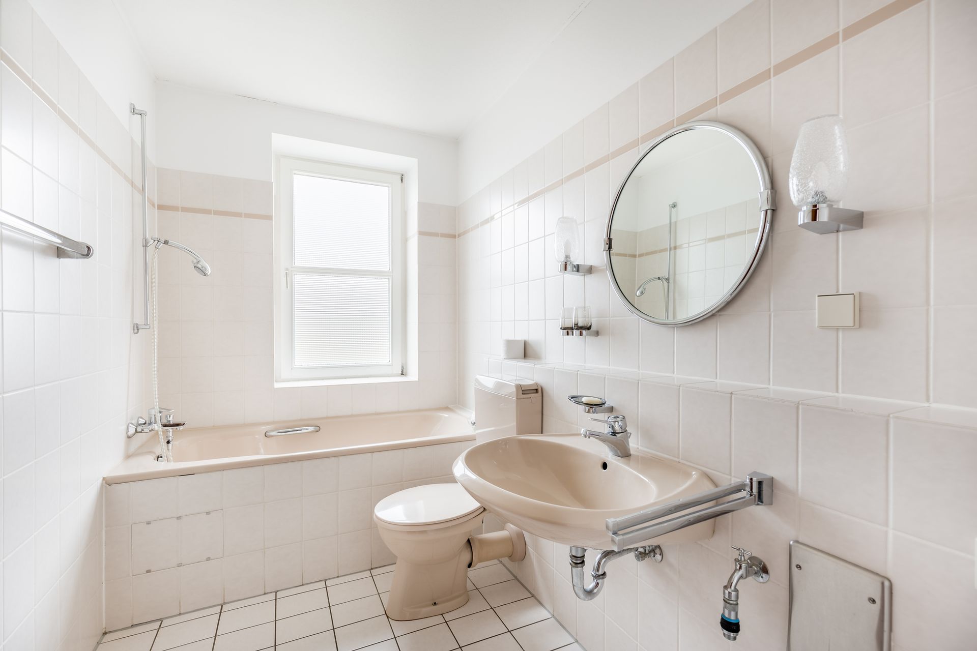 Beige vinyl fence in a backyard, with two-story houses in the background on a sunny day.
