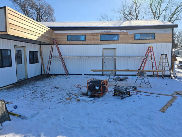 Interior of a garage under construction with wood framing and exposed rafters.