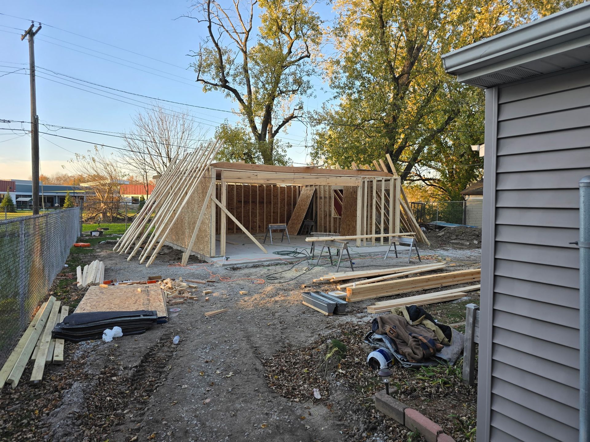 Man in hard hat inspecting open garage, holding tablet and a remote.