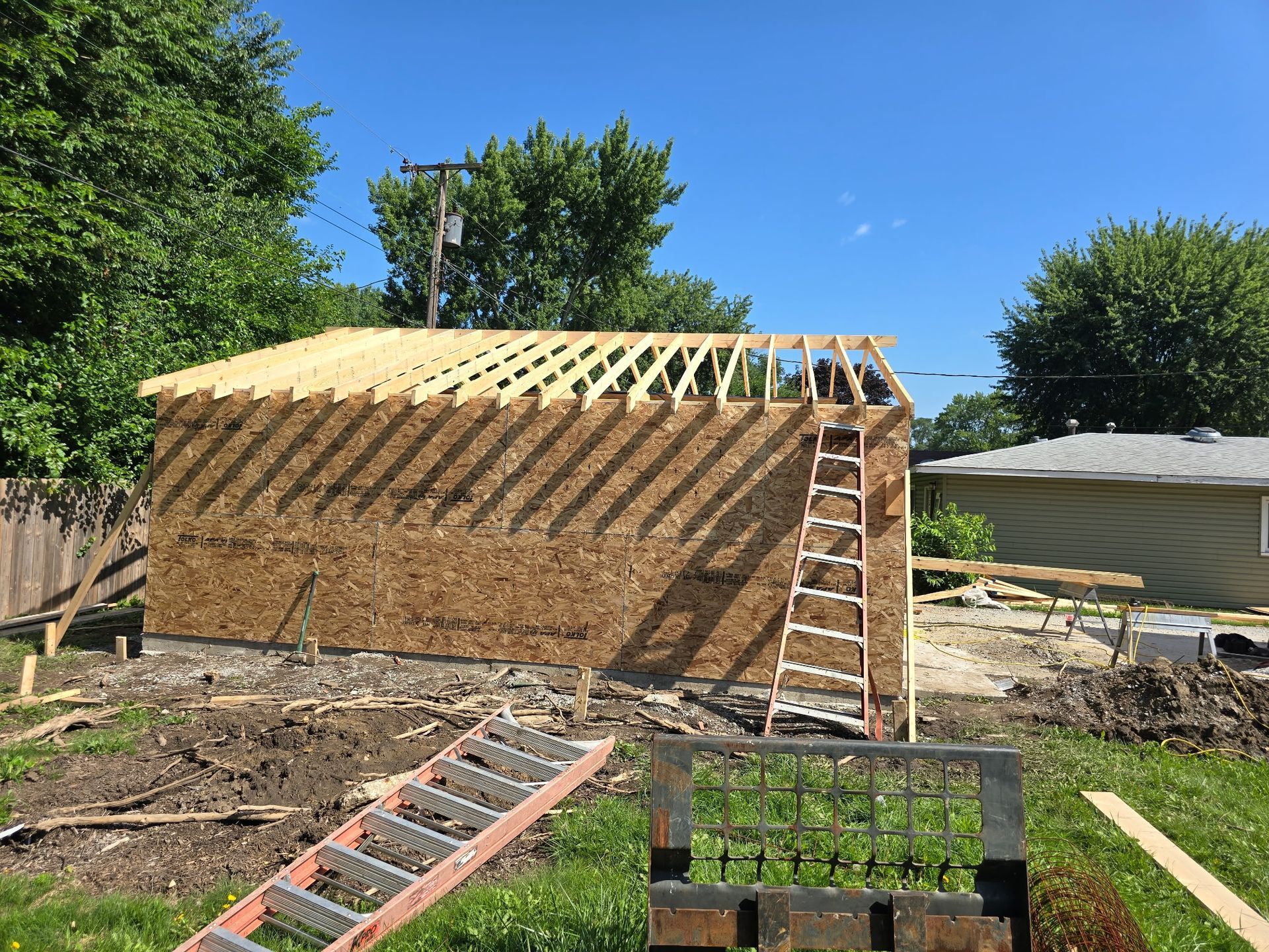 Man carrying a boat through a boathouse filled with stored racing shells.
