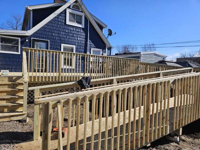 Carpenter on a wooden roof frame, hammering. Bright sunlight.