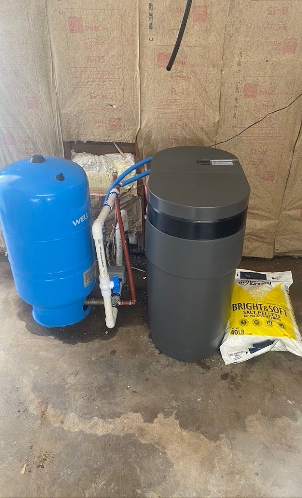 Cowboys Plumbing - Blue water tank and a gray water softener next to a bag of salt.
