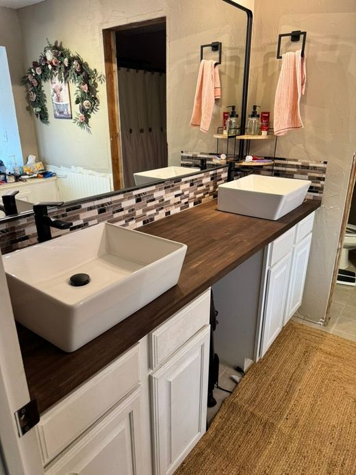 Bathroom renovation in progress: green drywall, tiled tub surround, window, and plumbing fixtures.