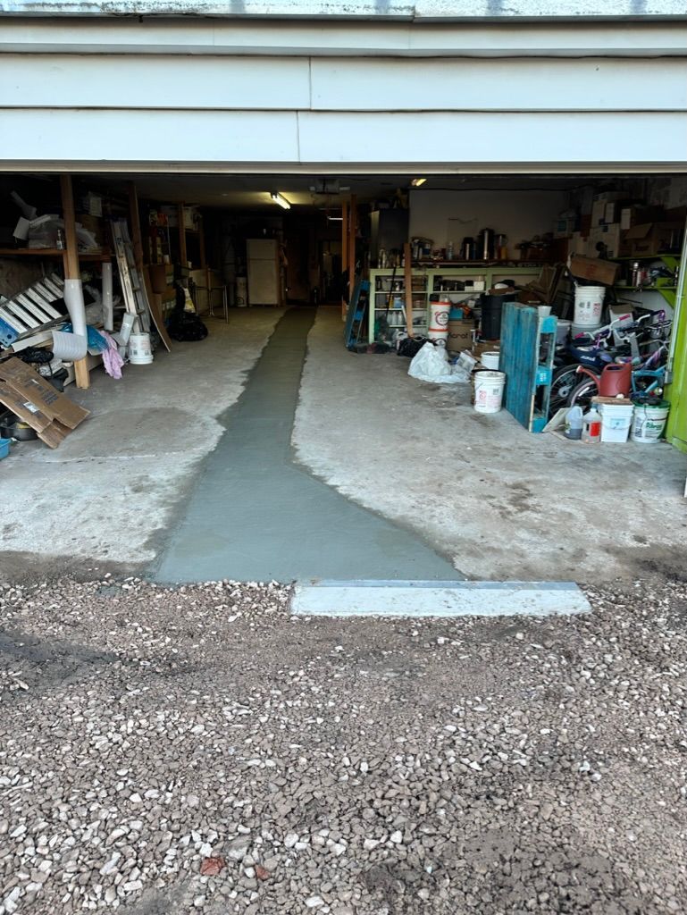 Cowboys Plumbing - Garage entrance with a newly poured concrete path leading inside. Gravel driveway.