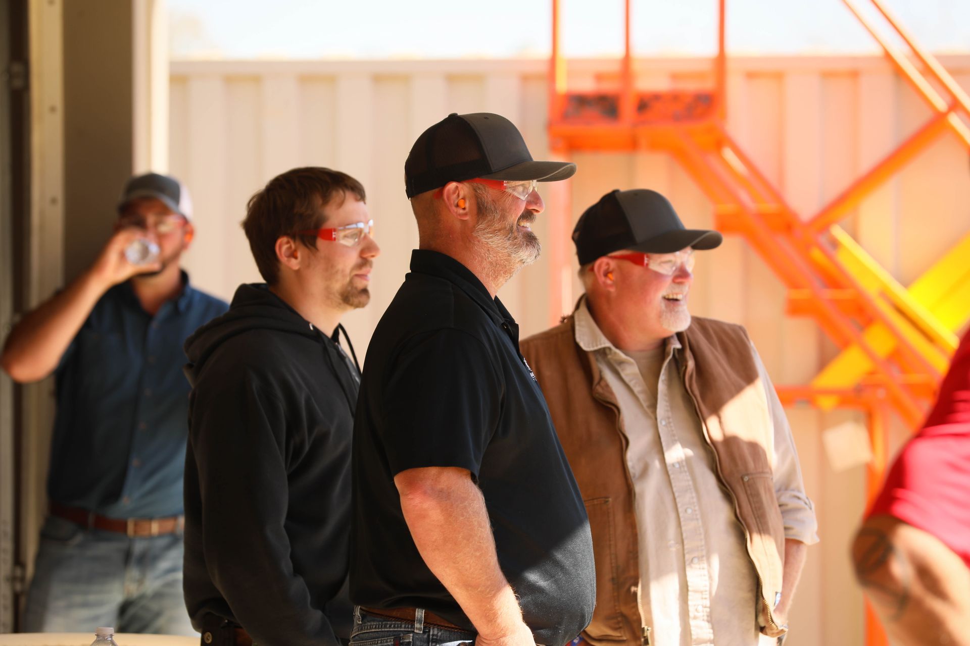 A group of men are standing next to each other wearing safety goggles.