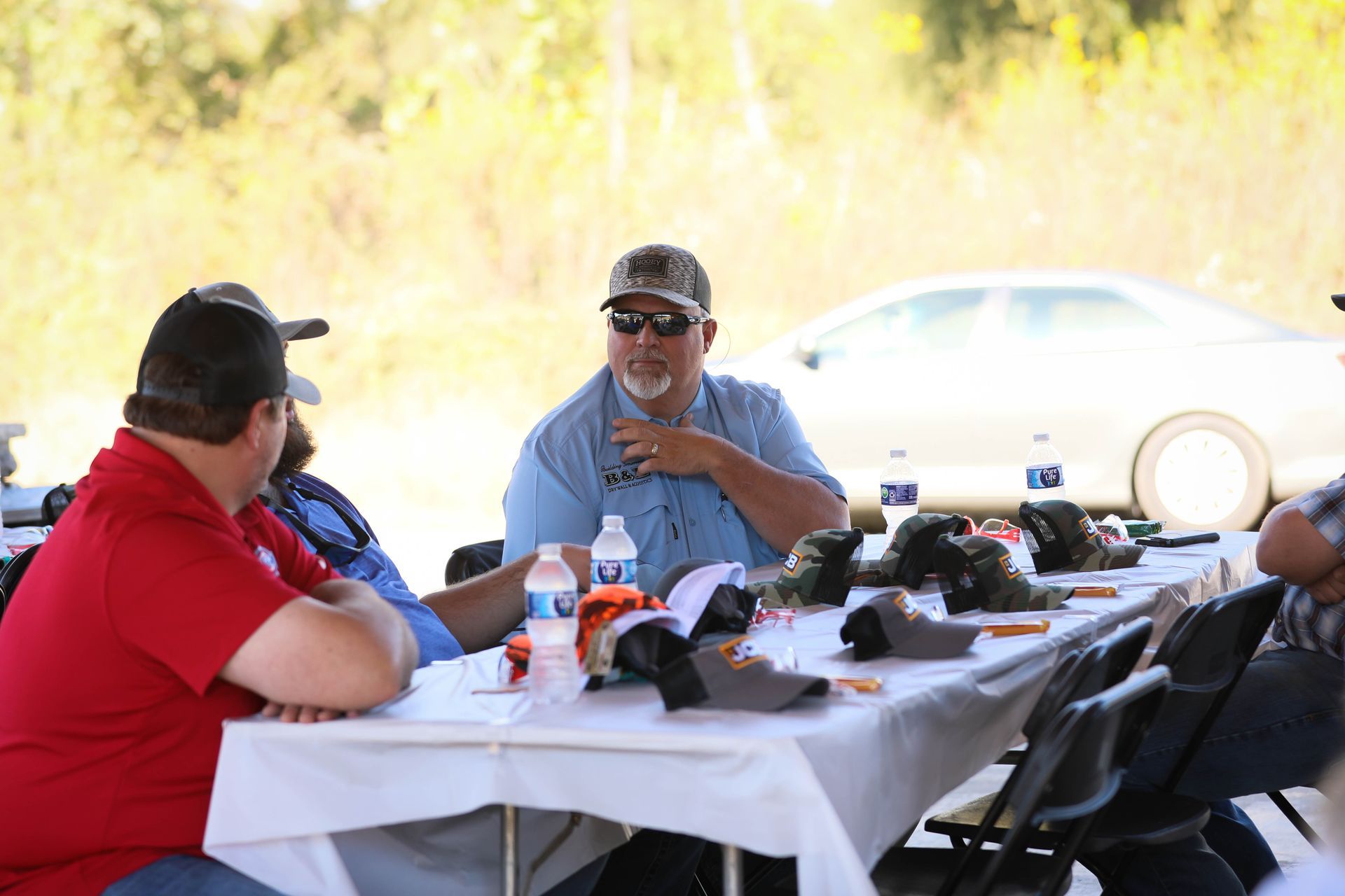 A group of men are sitting at a table talking to each other.