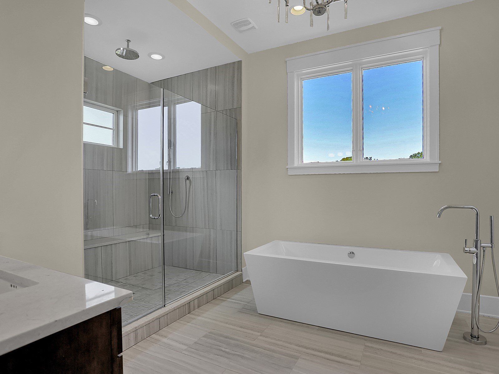 A bathroom with a tub , shower and window.