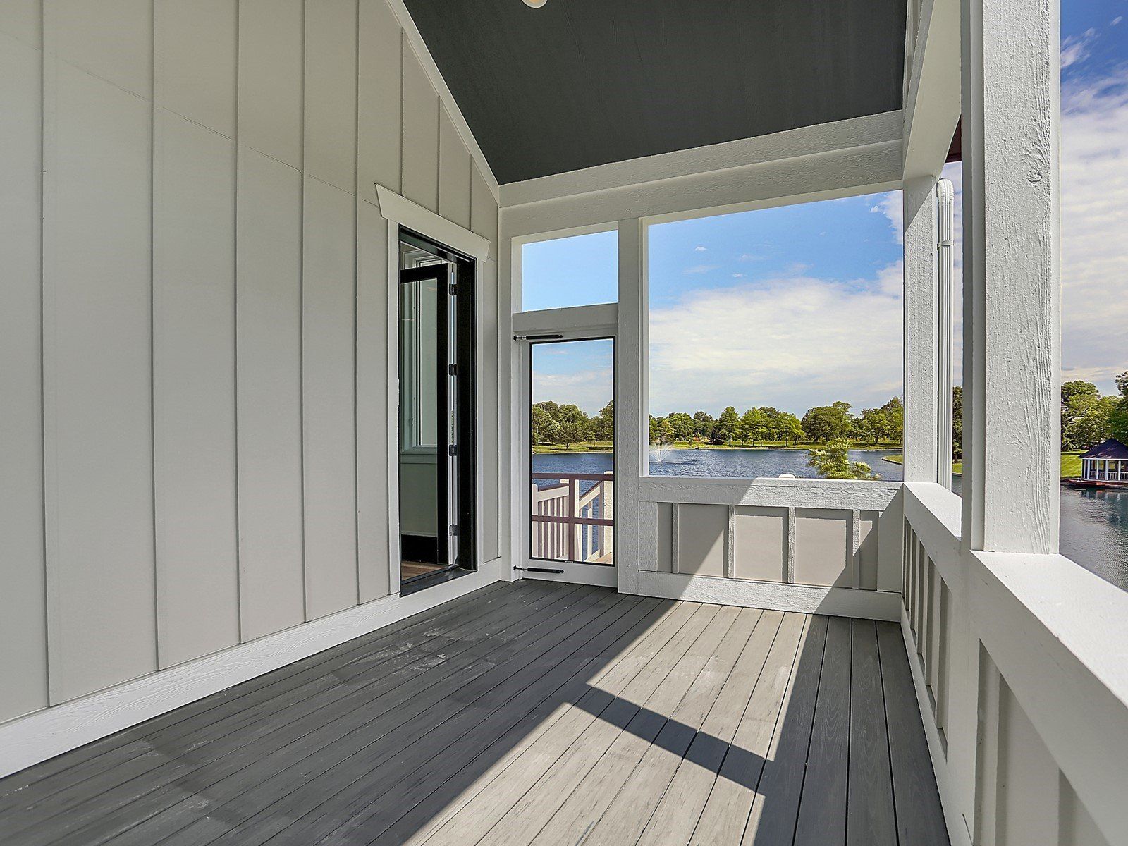 A screened in porch with a view of a lake.
