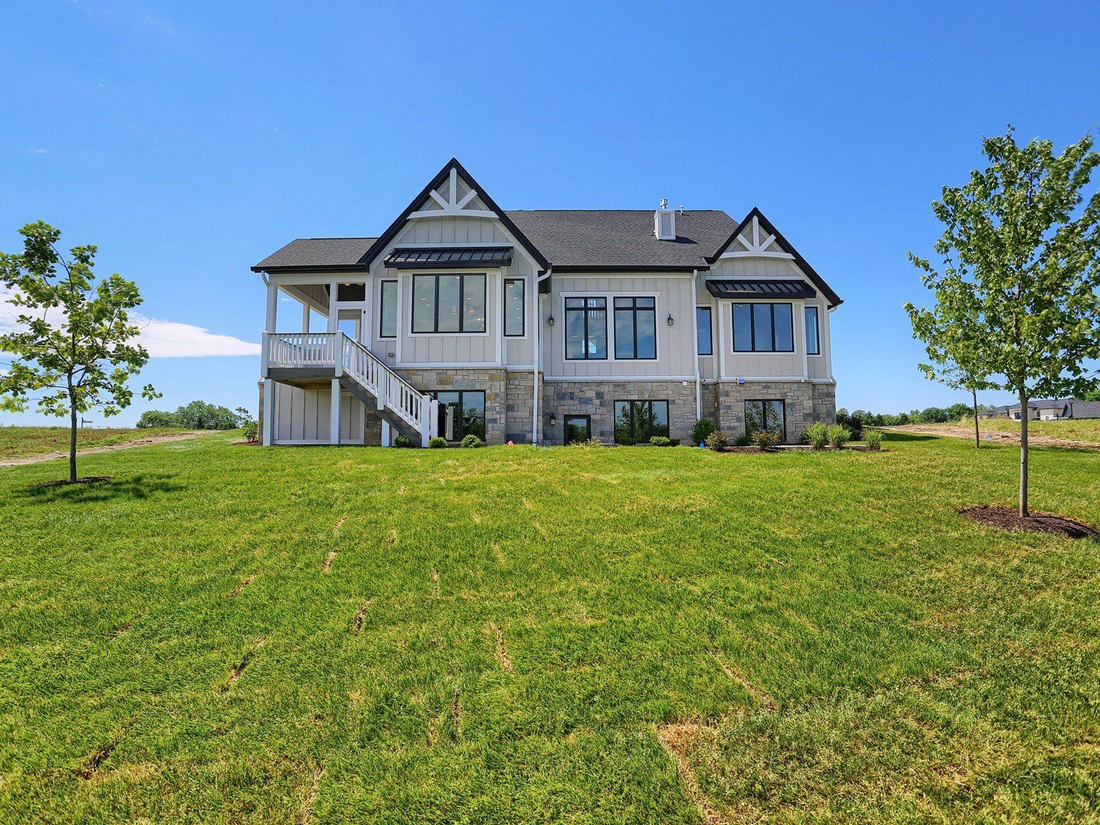 A large house is sitting on top of a lush green field.