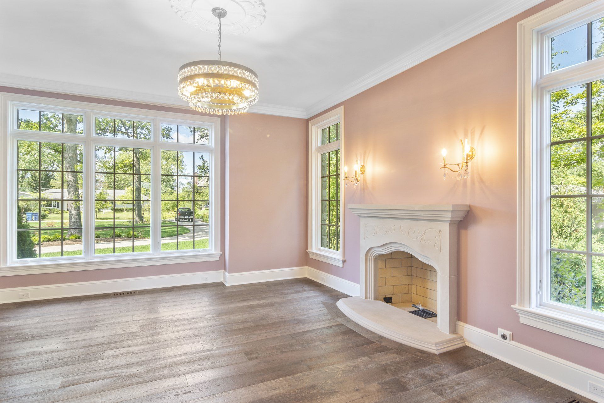 An empty living room with a fireplace and lots of windows.