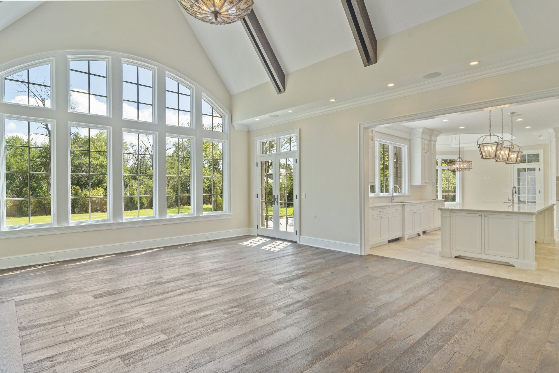 A large empty room with hardwood floors and lots of windows.