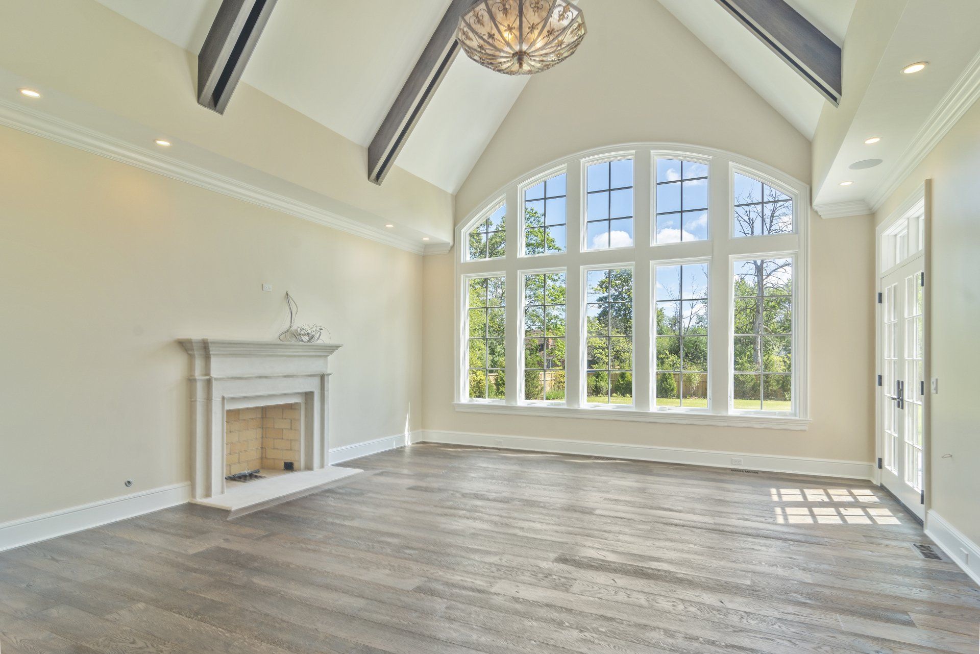 An empty living room with a fireplace and lots of windows.