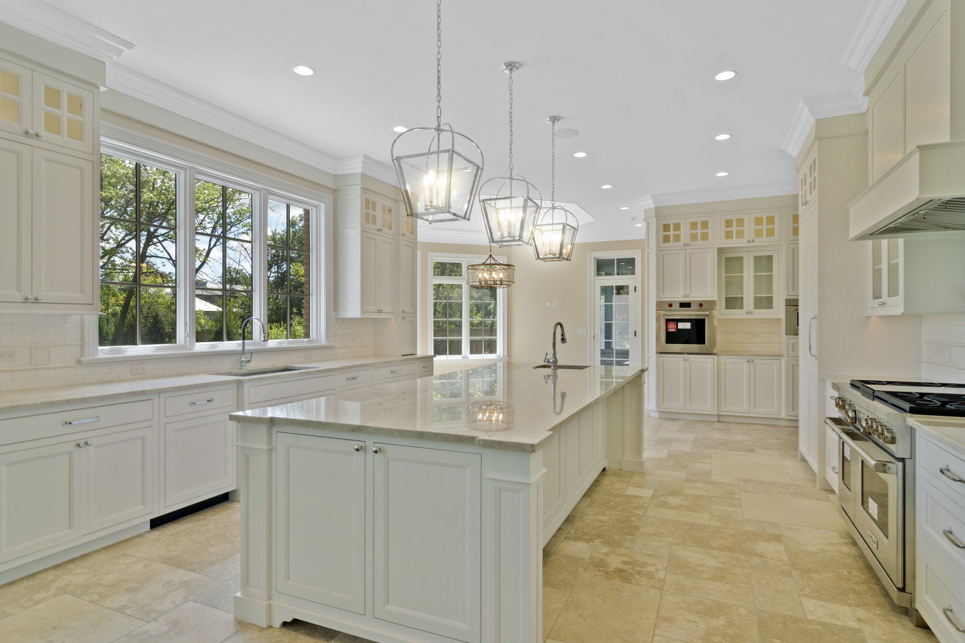 A large kitchen with white cabinets and a large island.