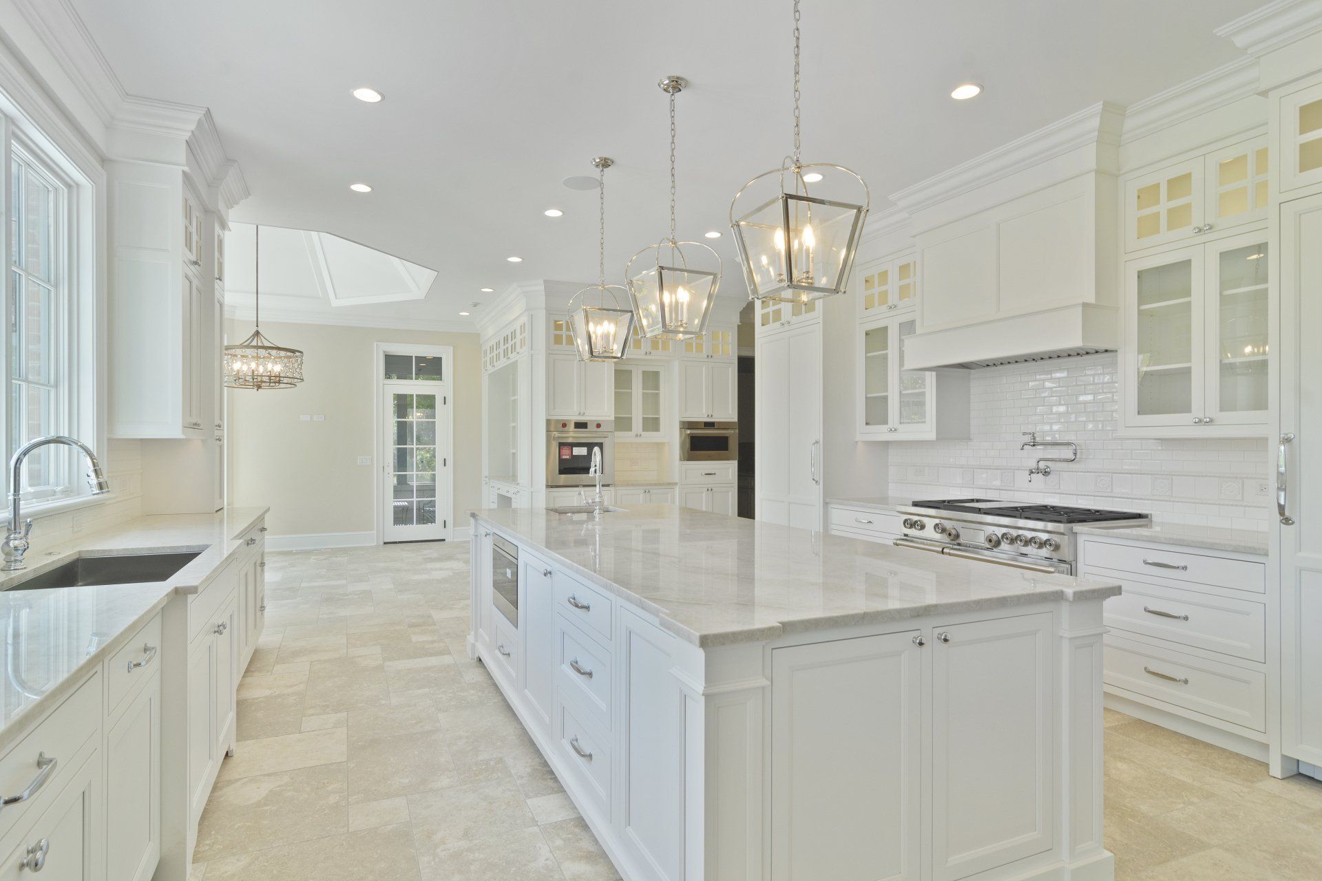A large kitchen with white cabinets and a large island.