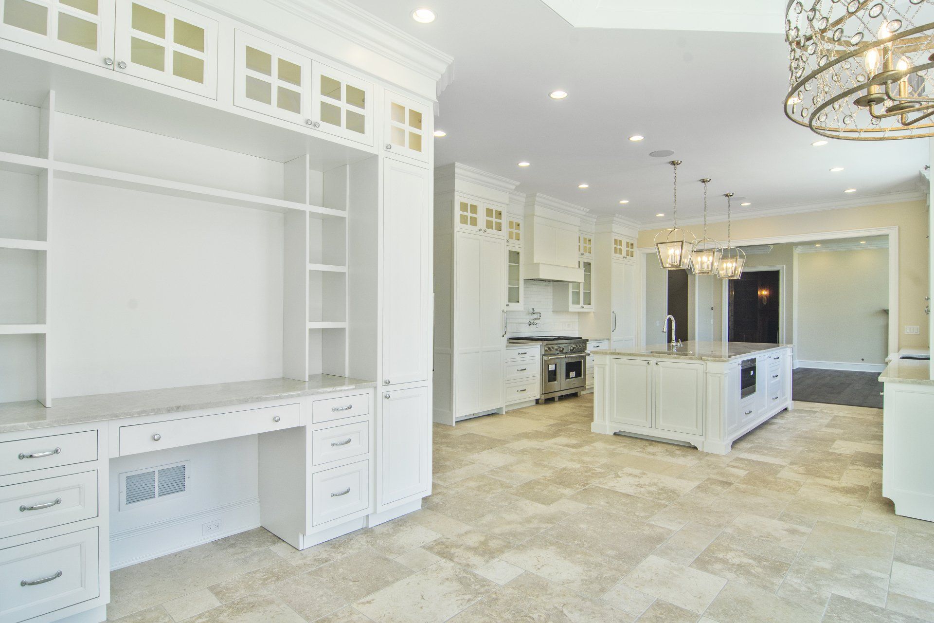 There is a desk in the middle of the room in the kitchen.
