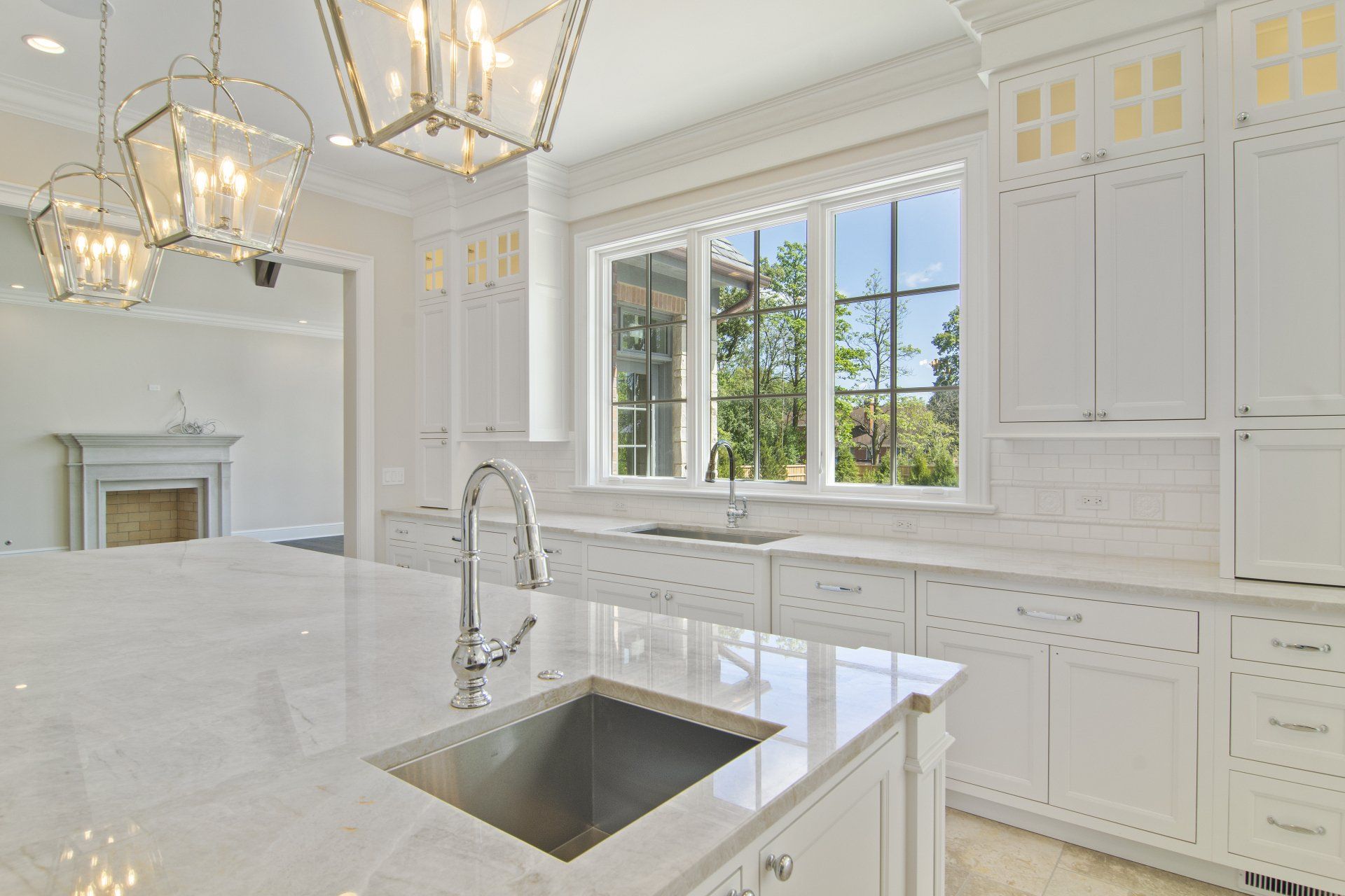 A kitchen with white cabinets and a stainless steel sink.