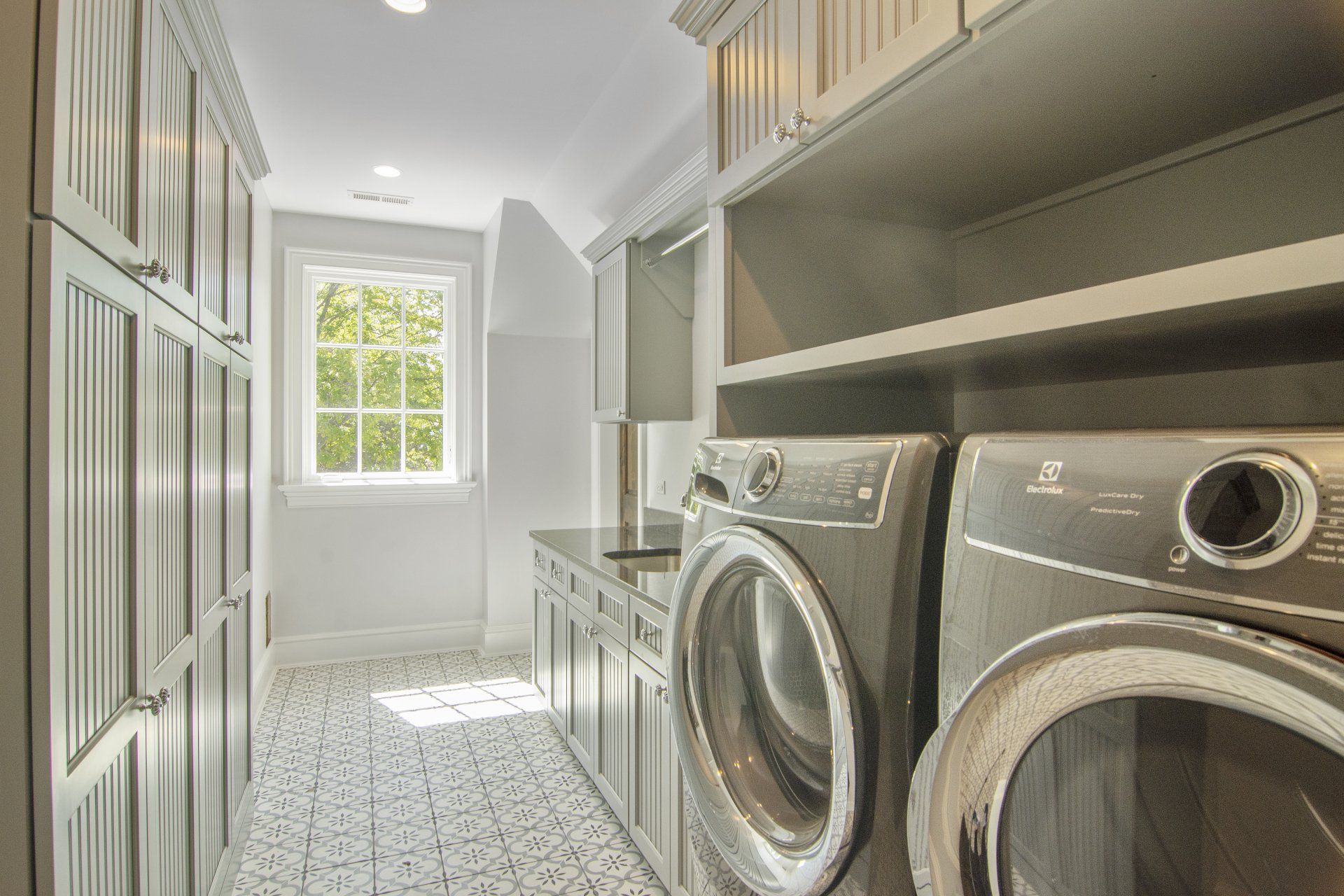 A laundry room with a washer and dryer and a window.