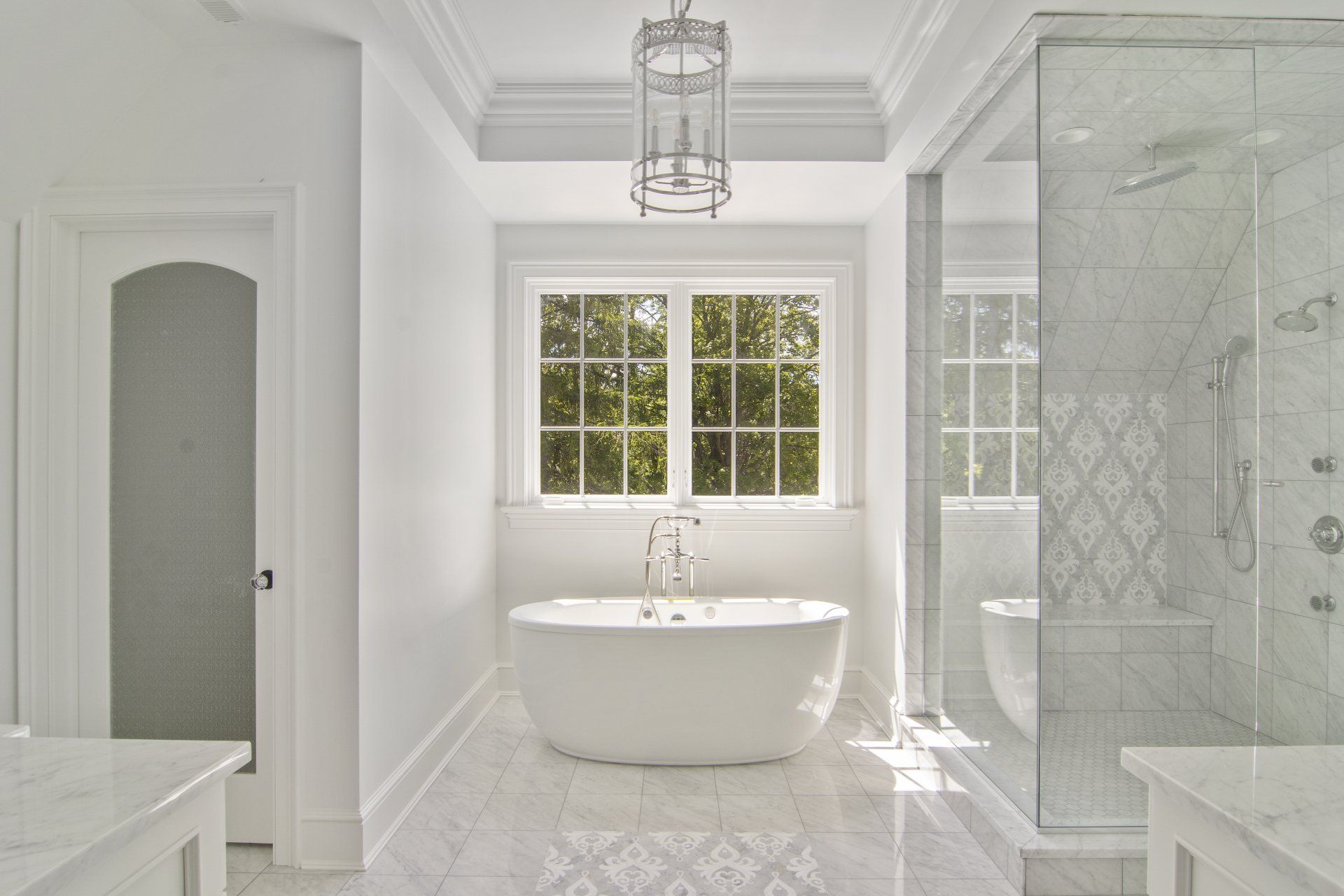 A bathroom with a tub , shower , and window.