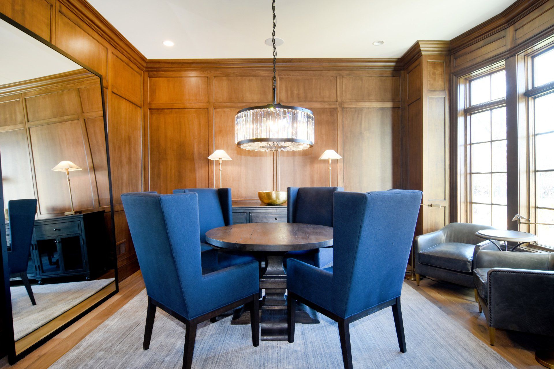 A dining room with a round table and blue chairs