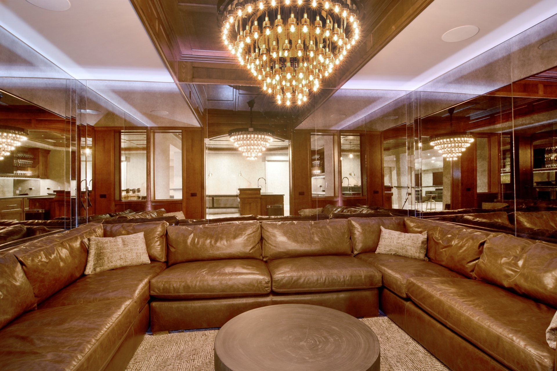 A living room with a large sectional couch and a chandelier
