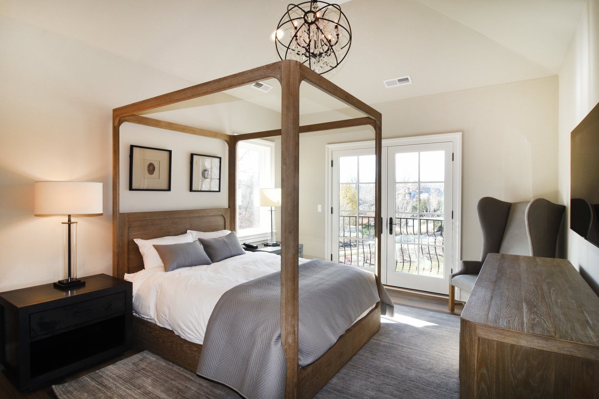 A bedroom with a four poster bed and a balcony