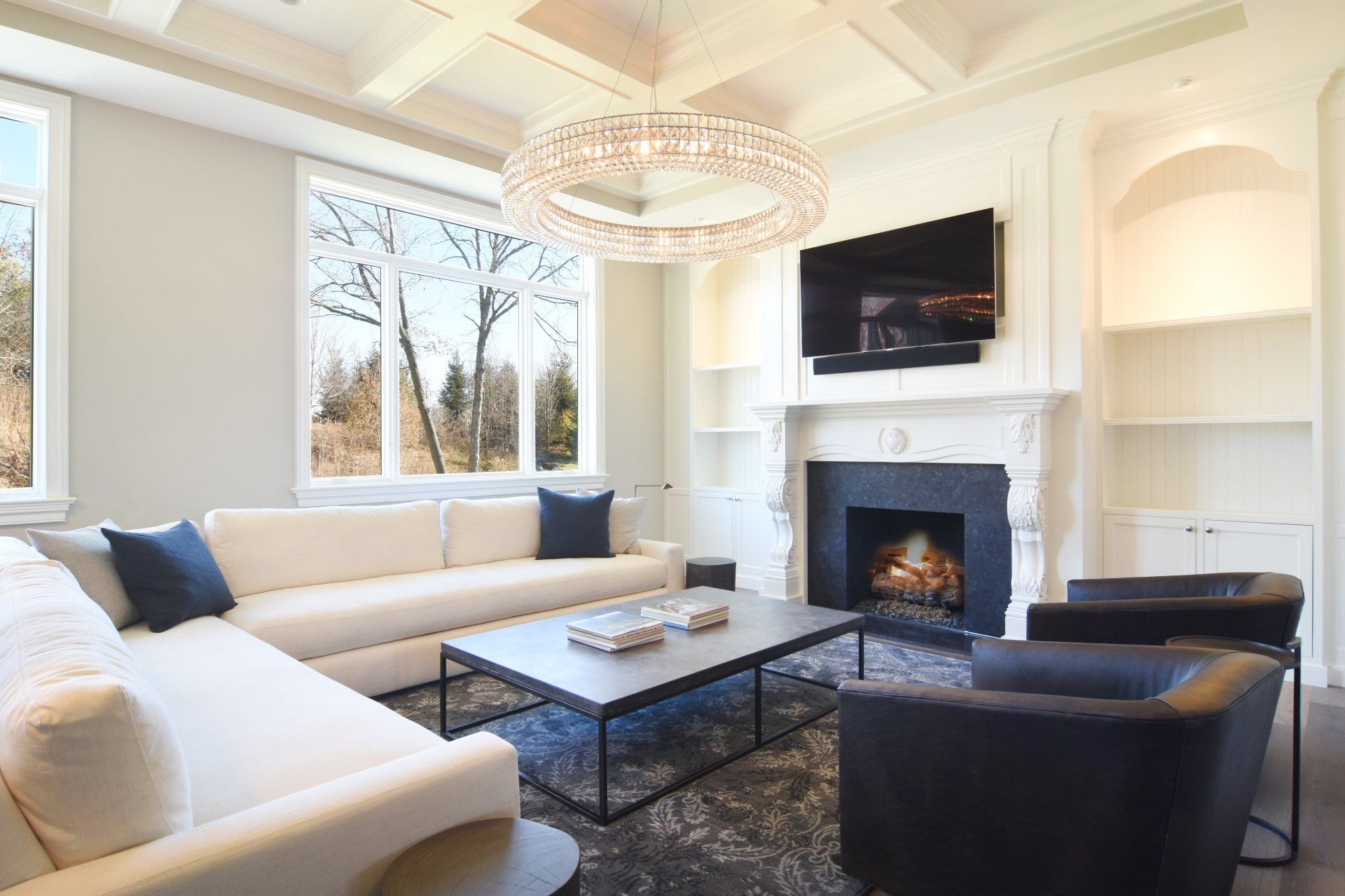 A living room with a fireplace , couch , chairs , coffee table and television.