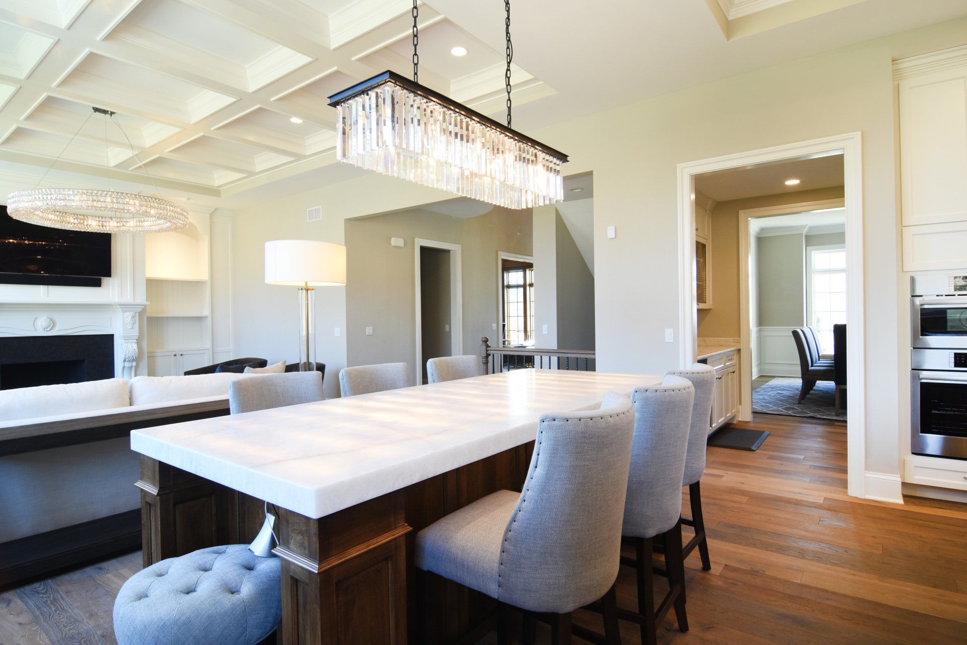 A dining room with a large table and chairs and a chandelier hanging from the ceiling.