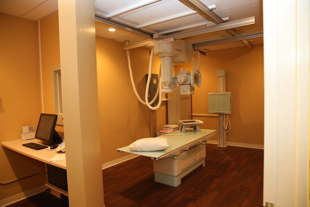 An x-ray machine is sitting on top of a table in a room.
