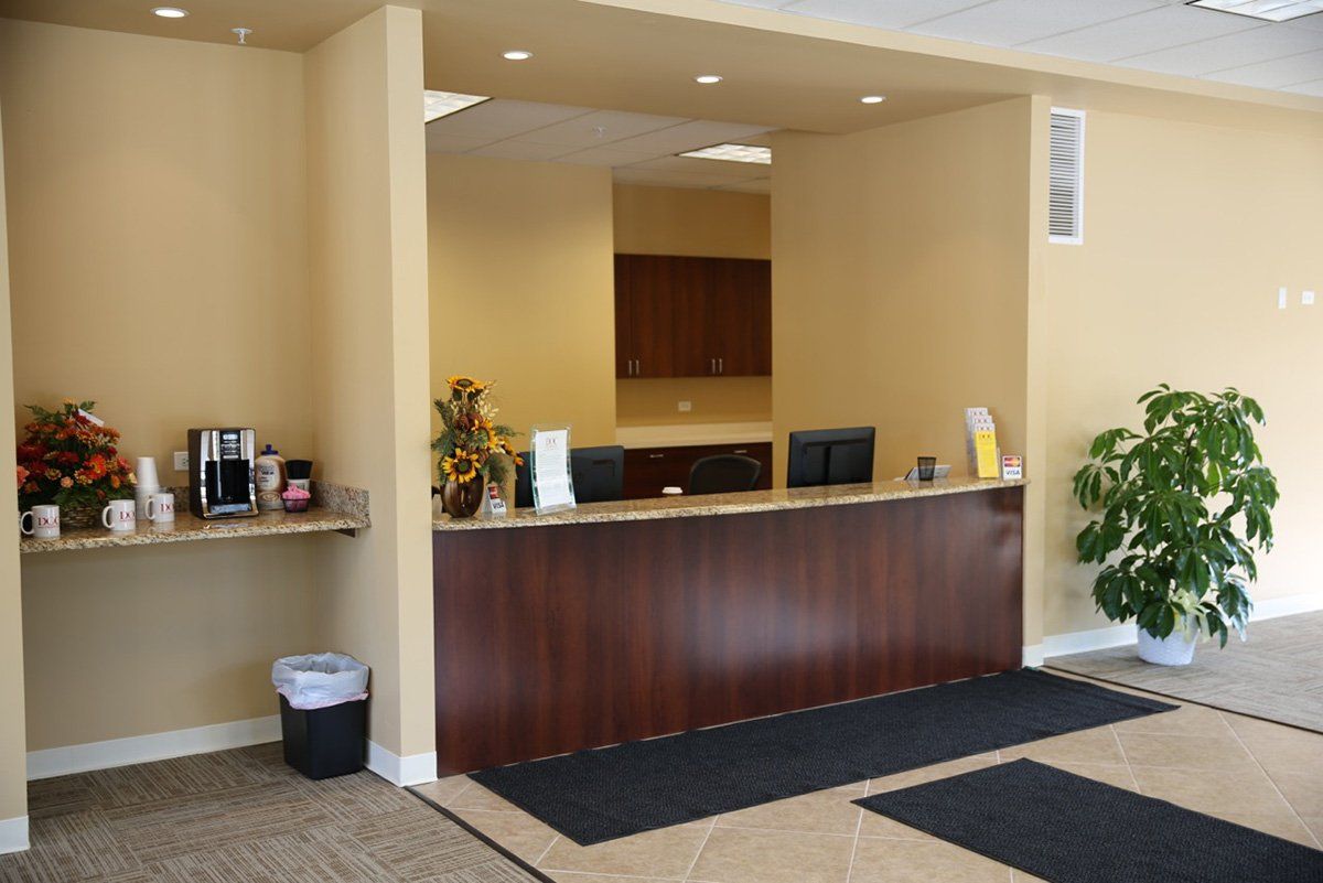 A lobby with a wooden counter and a plant