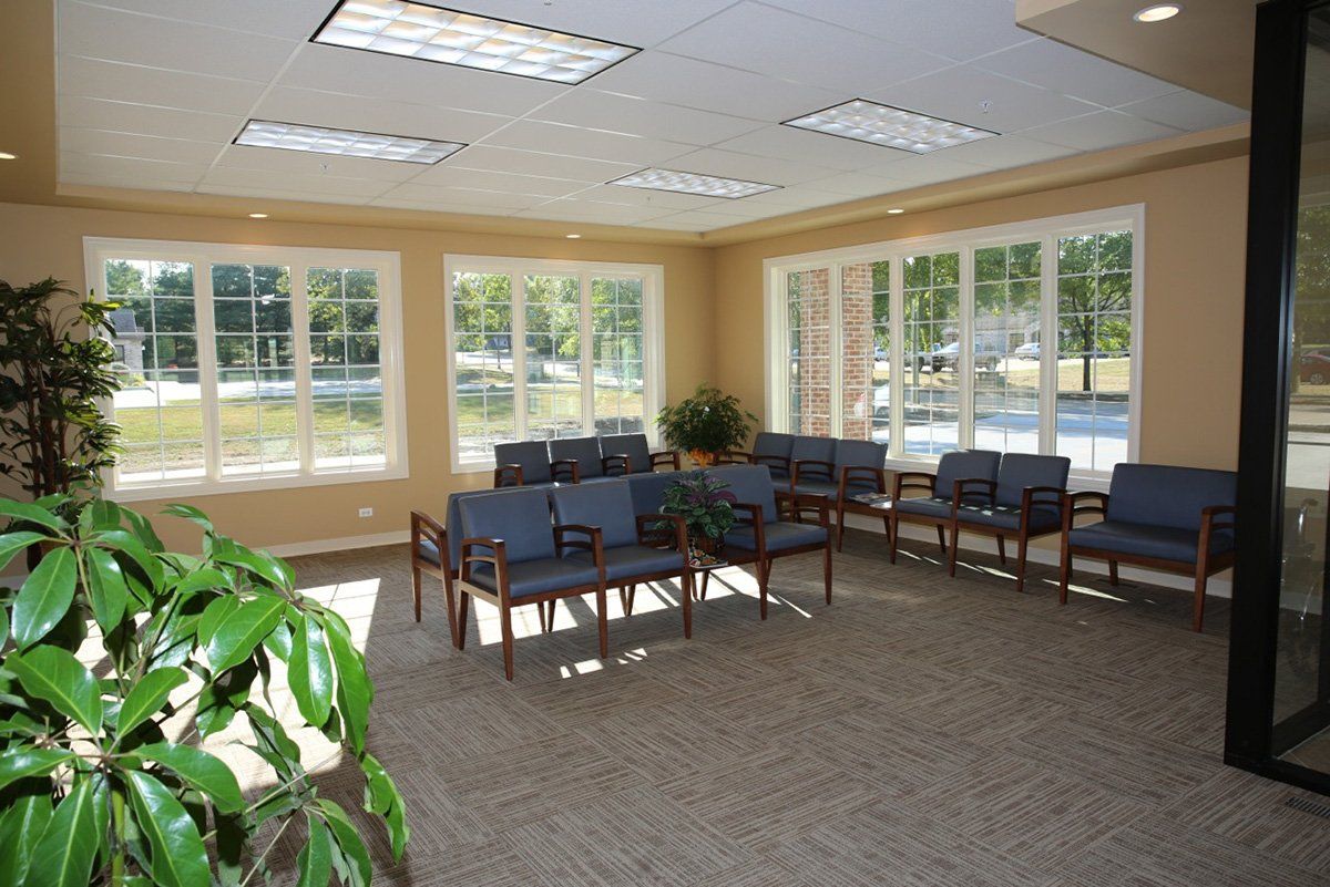A waiting room with lots of chairs and windows