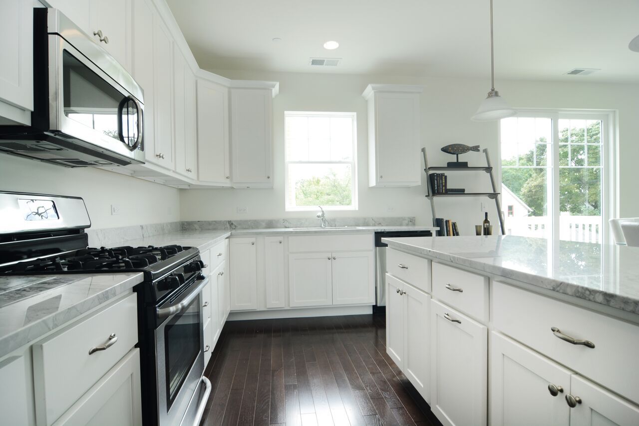 A kitchen with white cabinets and stainless steel appliances