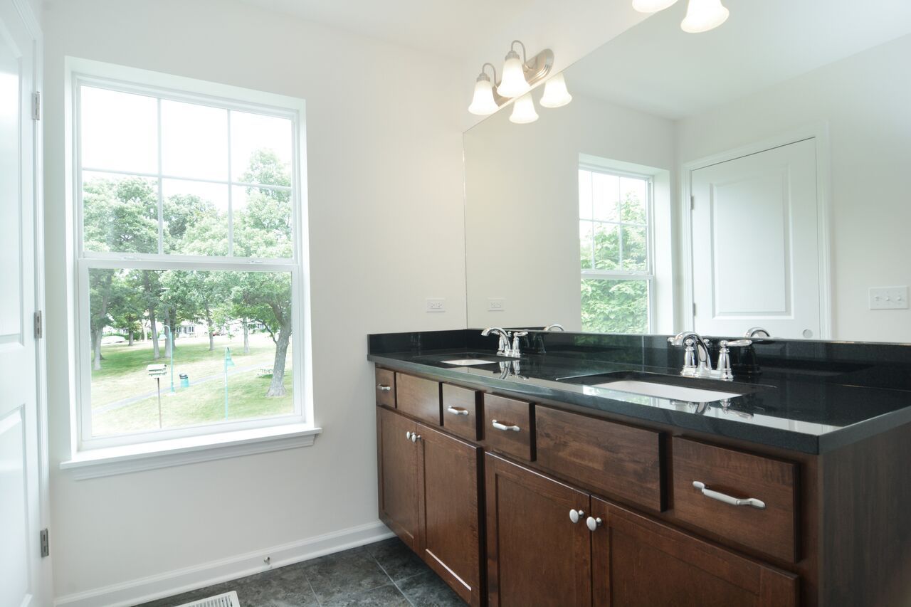 A bathroom with two sinks and a large mirror.