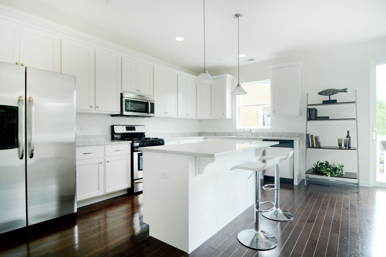 A kitchen with white cabinets and stainless steel appliances