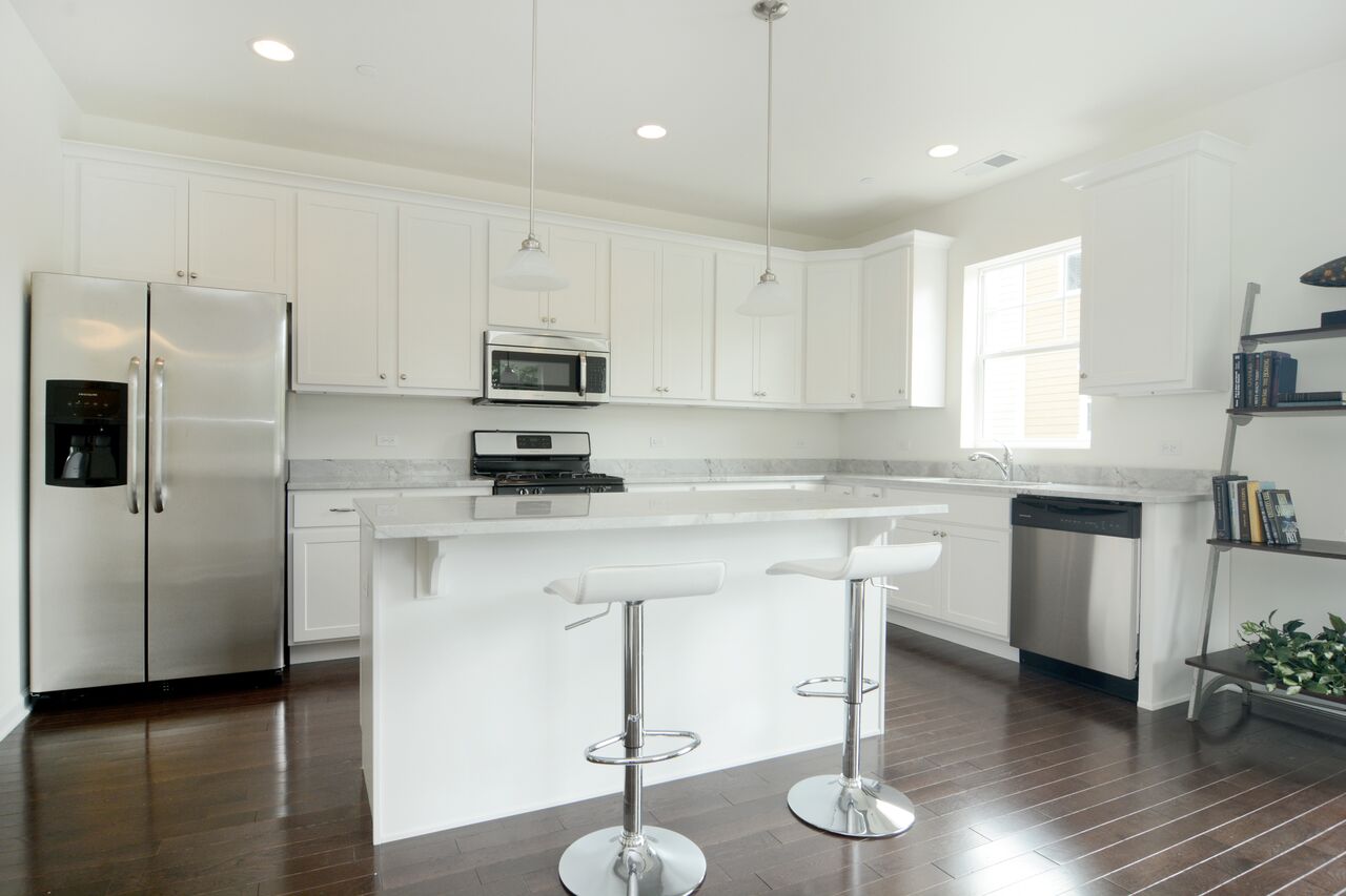 A kitchen with white cabinets and stainless steel appliances