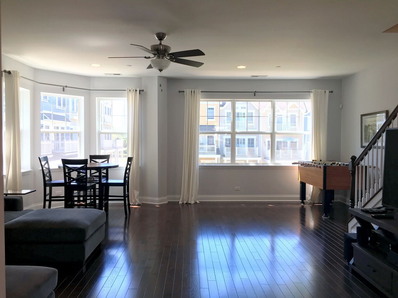 A living room with a ceiling fan and a foosball table