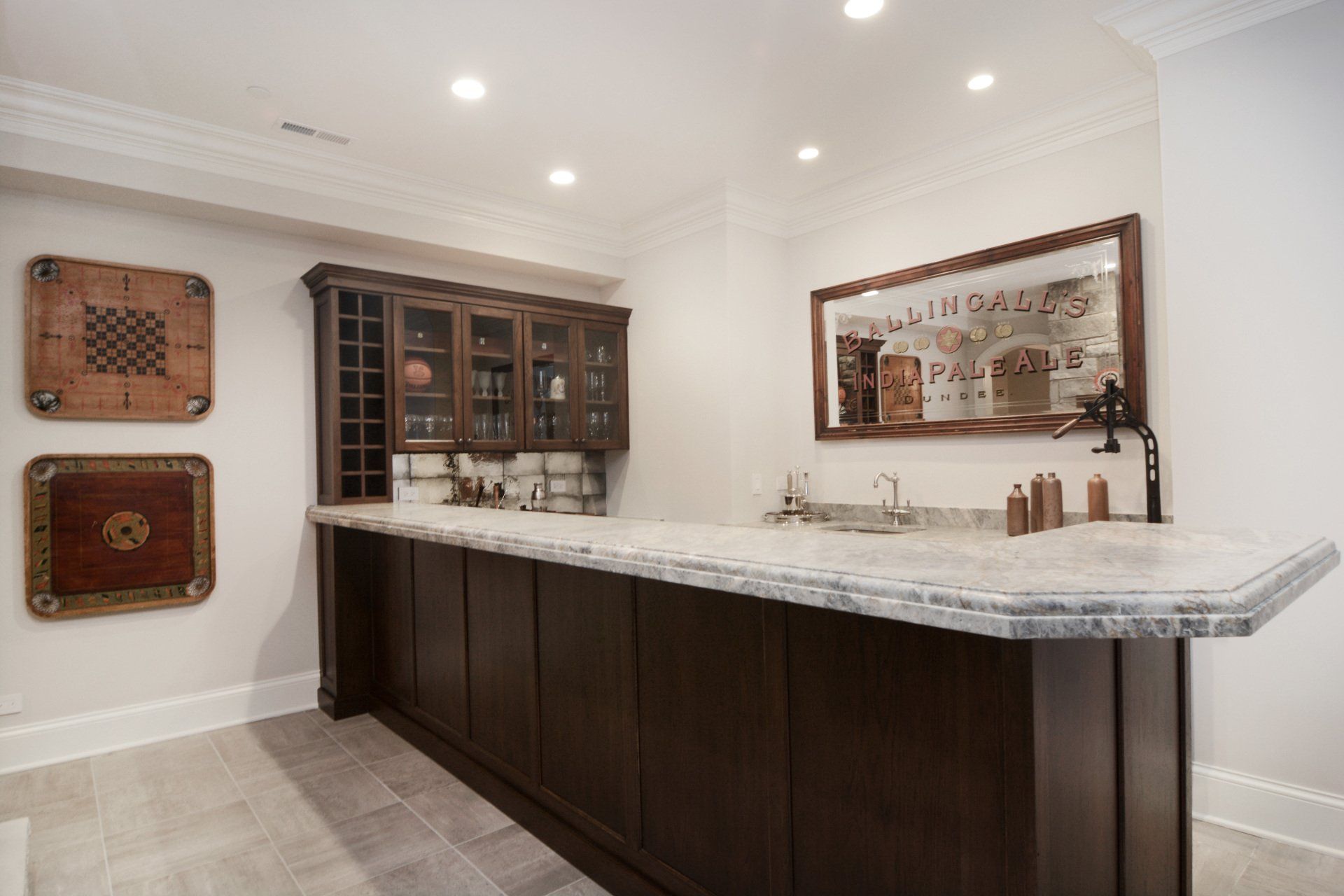 A kitchen with a long bar and a mirror on the wall