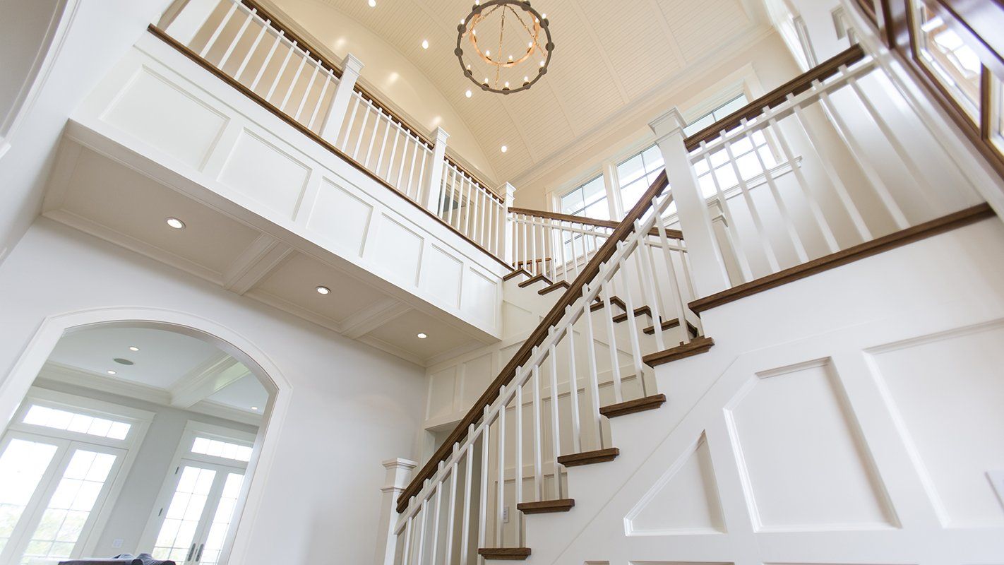 A staircase in a house with a chandelier hanging from the ceiling.