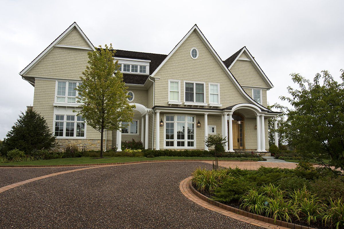 A large house with a gravel driveway in front of it