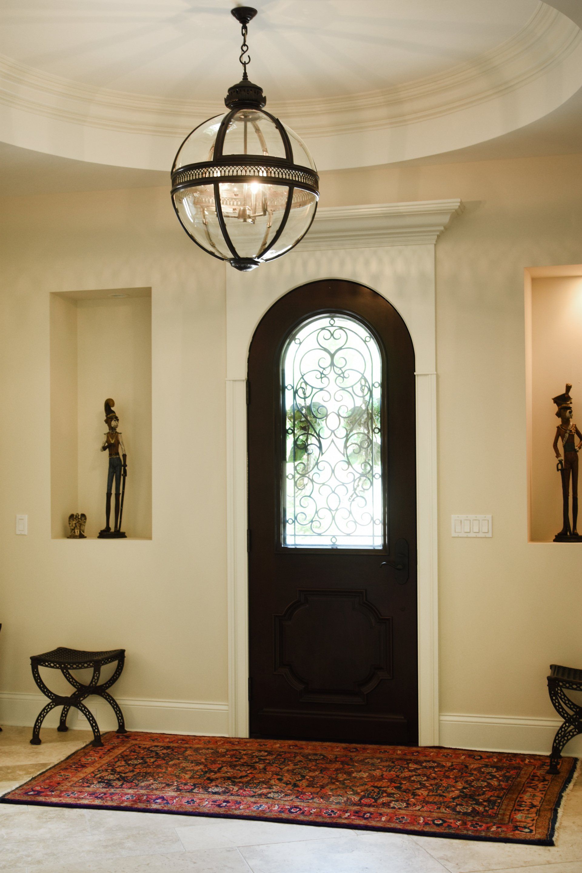 A hallway with a rug and a chandelier hanging from the ceiling.