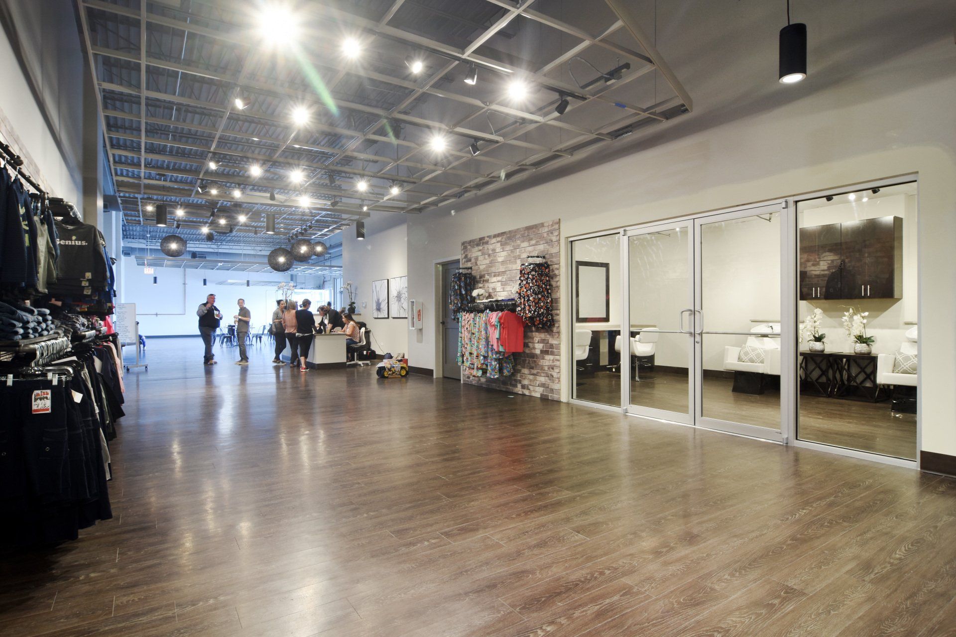 A large empty room with a wooden floor and a glass door.