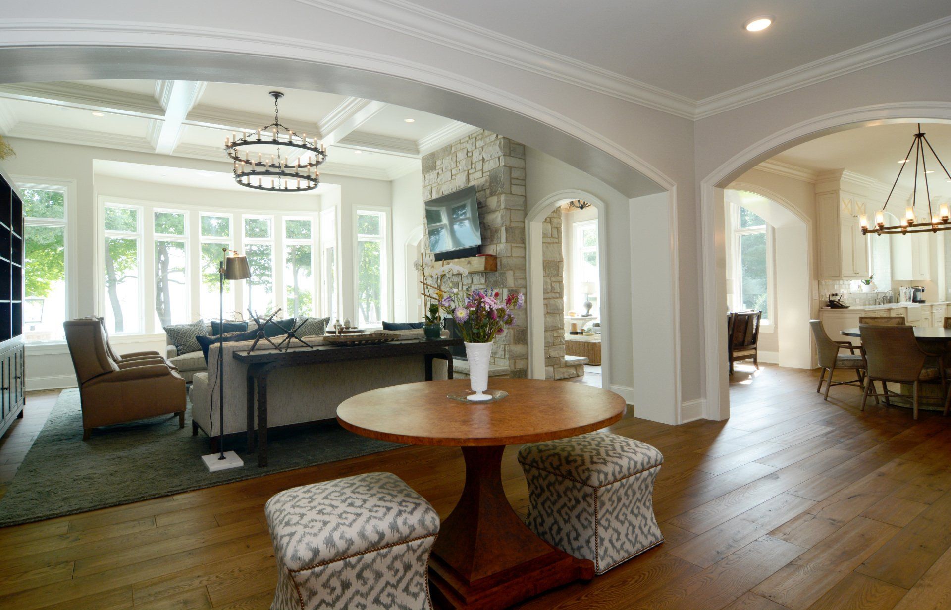 A living room with a round table and ottomans