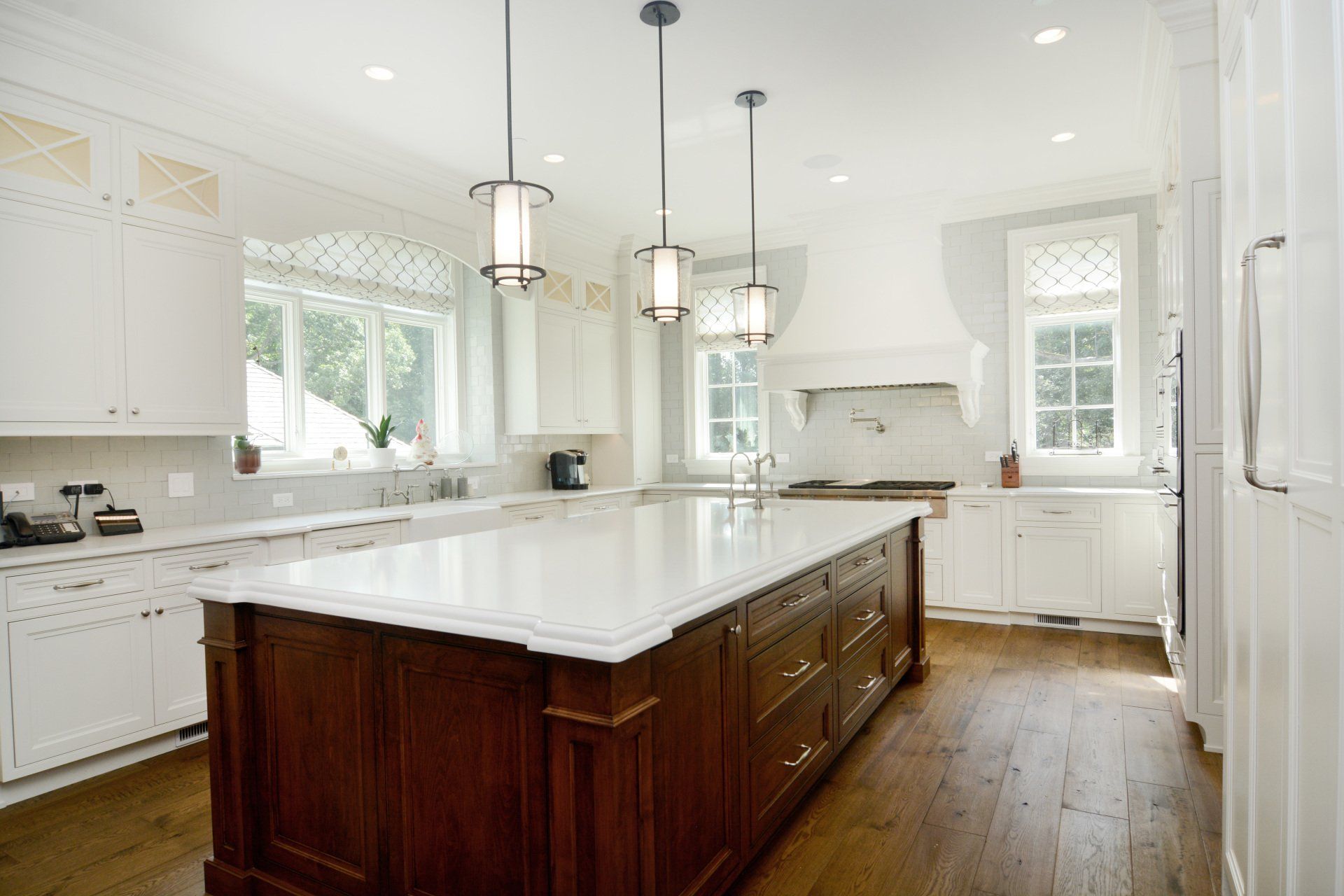 A kitchen with white cabinets and a large island in the middle.