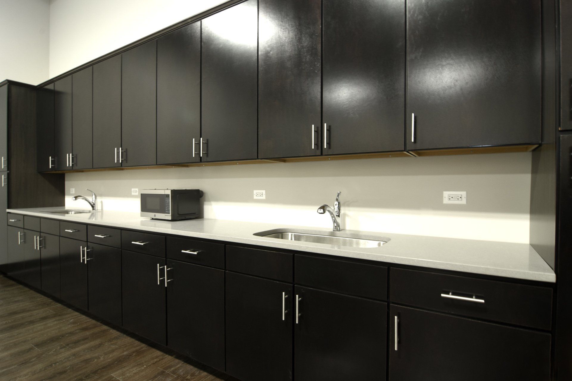 A kitchen with black cabinets and white counter tops
